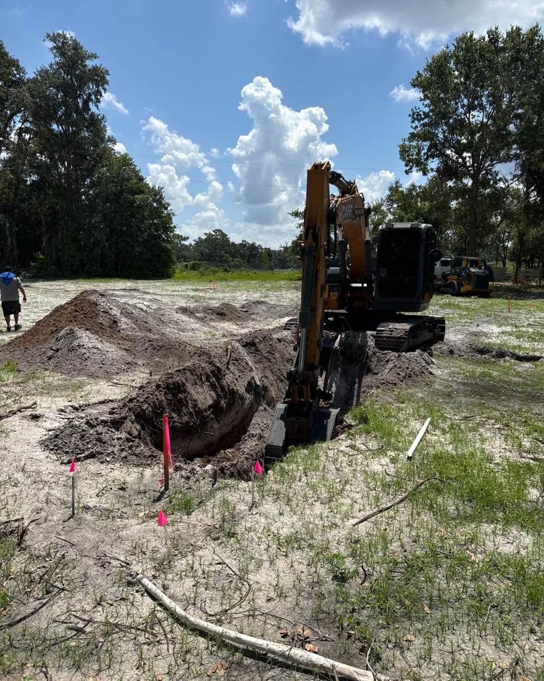 Excavator digging a drainage trench during site preparation